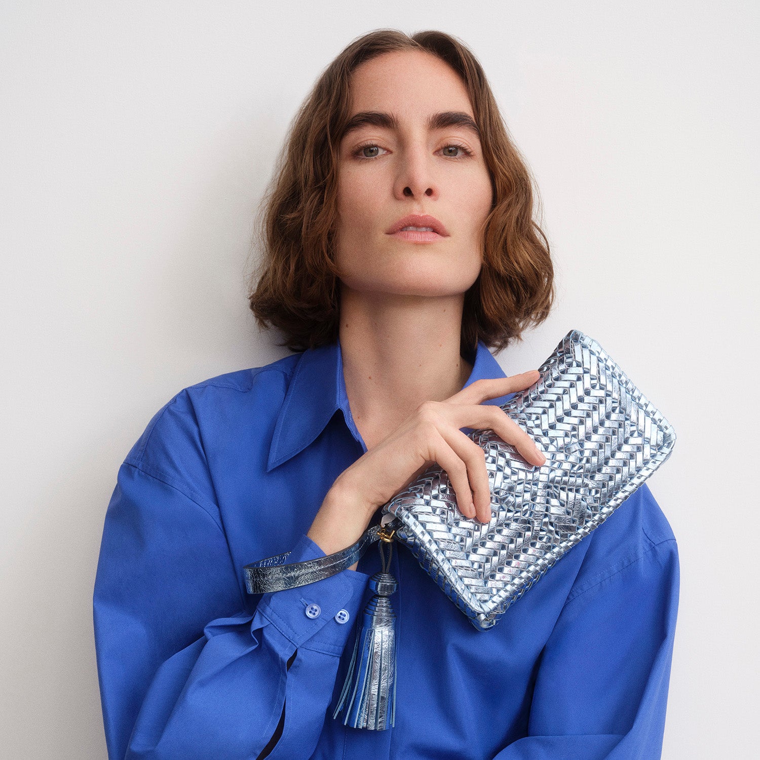 Metallic blue handwoven leather clutch by Anya Hindmarch