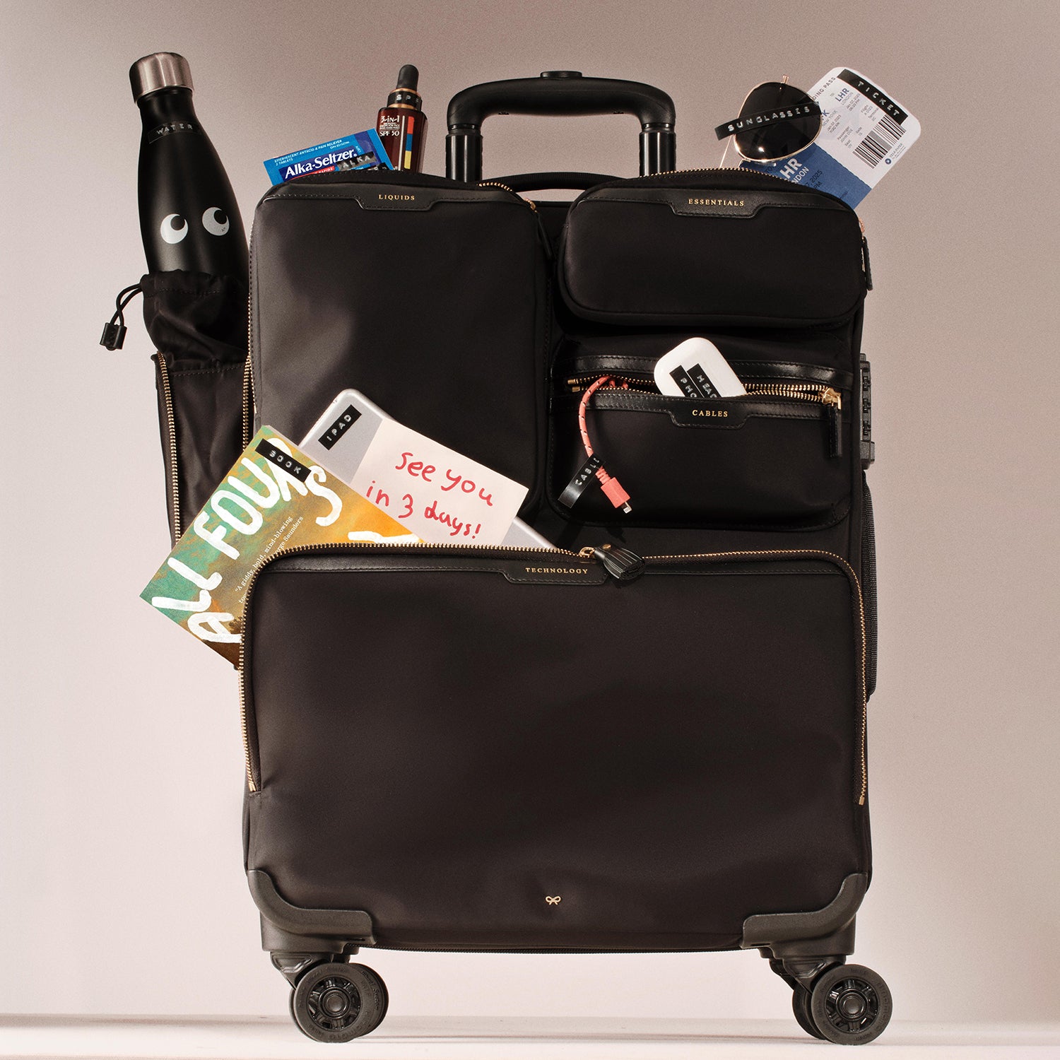 Short-Haul Suitcase -

          
            Econyl® Regenerated Nylon in Black -
          

          Anya Hindmarch UK
